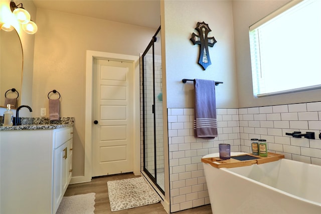 130 County Road 2630, Decatur, TX 76234 - full bathroom featuring a shower stall, wood finished floors, a freestanding bath, vanity, and tile walls