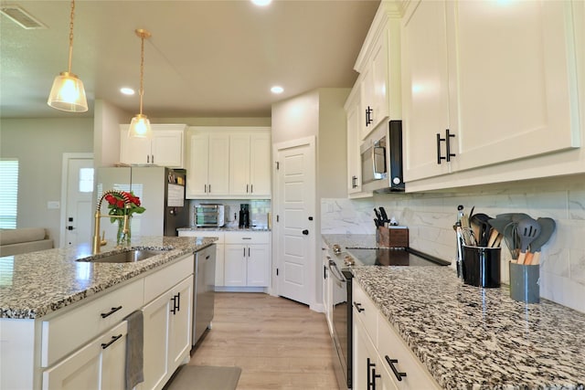 130 County Road 2630, Decatur, TX 76234 - kitchen with appliances with stainless steel finishes, a sink, recessed lighting, decorative backsplash, and light wood-type flooring