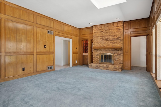1706 Morningstar Trl, Richardson, TX 75081 - unfurnished living room featuring a skylight, wood walls, a fireplace, and light carpet