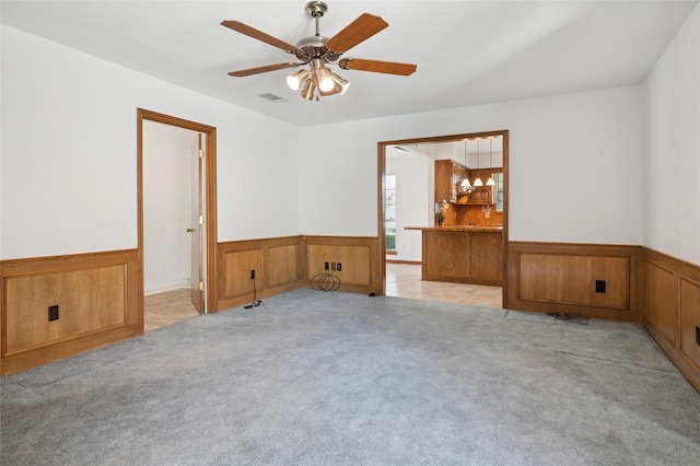 1706 Morningstar Trl, Richardson, TX 75081 - spare room featuring a wainscoted wall, light carpet, a ceiling fan, and wood walls