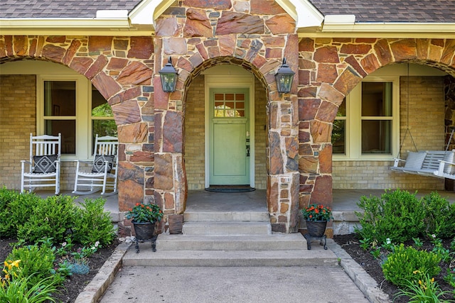 1143 N Winnetka Ave, Dallas, TX 75208 - view of exterior entry with roof with shingles and brick siding