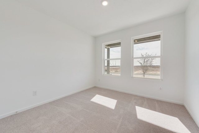 spare room featuring light colored carpet, baseboards, and recessed lighting