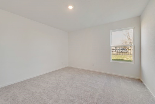 spare room featuring light carpet, baseboards, and recessed lighting