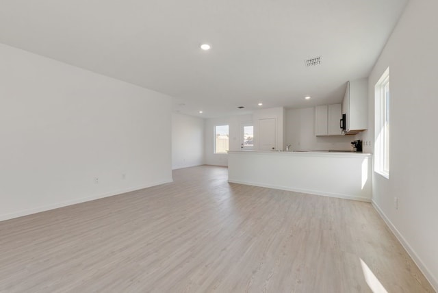 unfurnished living room with light wood-style floors, recessed lighting, and baseboards