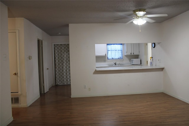 314 Cedar St, Bangs, TX 76823 - unfurnished living room featuring dark wood-style flooring, ceiling fan, a sink, and baseboards