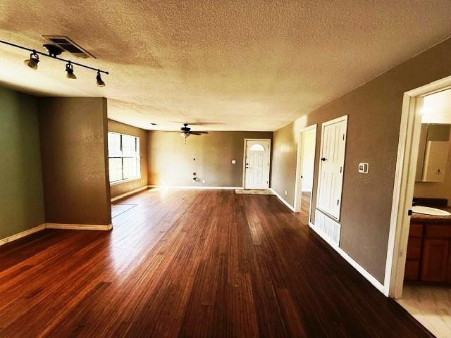 426 Gun Club Rd, Denison, TX 75021 - unfurnished living room with wood finished floors, a textured ceiling, baseboards, ceiling fan, and a sink