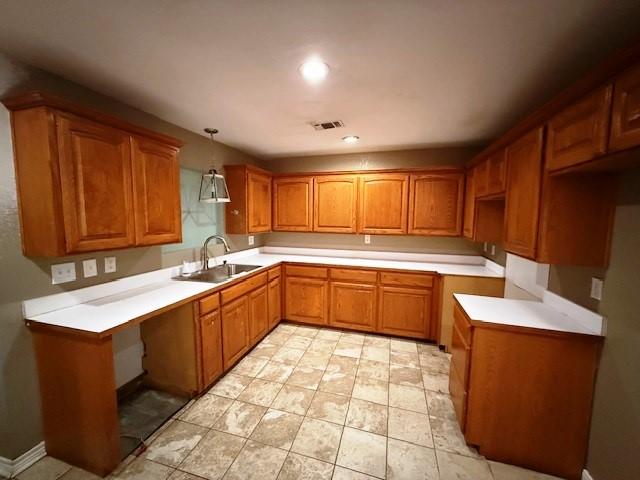 426 Gun Club Rd, Denison, TX 75021 - kitchen featuring a sink, brown cabinetry, decorative light fixtures, light countertops, and recessed lighting