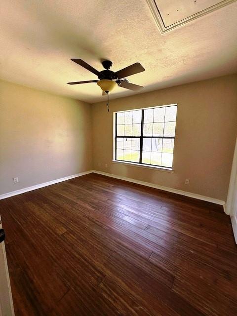 426 Gun Club Rd, Denison, TX 75021 - spare room with attic access, baseboards, a ceiling fan, dark wood-style flooring, and a textured ceiling