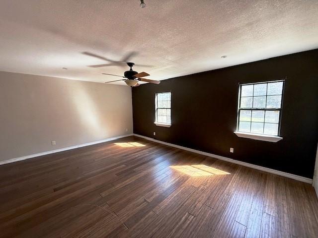 426 Gun Club Rd, Denison, TX 75021 - empty room featuring a textured ceiling, dark wood-type flooring, baseboards, and ceiling fan
