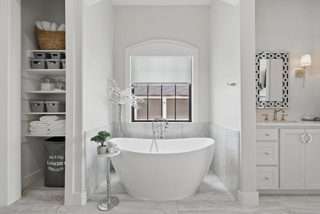 1316 Sparrow Hawk Ln, Gunter, TX 75058 - full bath featuring marble finish floors, a freestanding bath, vanity, and a wainscoted wall