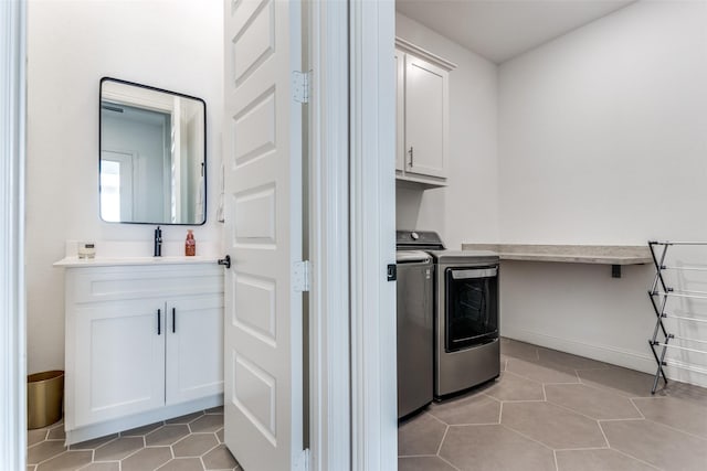 2228 Sandrellan St, Fort Worth, TX 76008 - laundry area featuring cabinet space, washer and dryer, light tile patterned floors, and baseboards