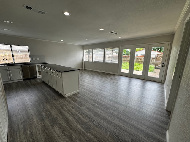 2910 Raintree Dr, Plano, TX 75074 - kitchen with dark countertops, ornamental molding, stainless steel dishwasher, dark wood-style flooring, and recessed lighting