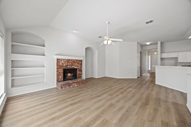 2402 Greenfield Cir, Garland, TX 75040 - unfurnished living room featuring built in features, a ceiling fan, a fireplace, plenty of natural light, and vaulted ceiling