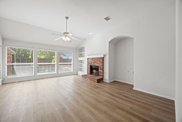 2402 Greenfield Cir, Garland, TX 75040 - unfurnished living room with built in features, ceiling fan, wood finished floors, baseboards, and vaulted ceiling