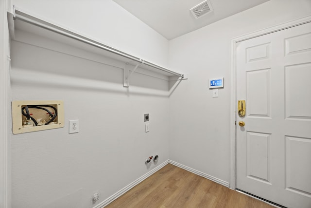 2402 Greenfield Cir, Garland, TX 75040 - laundry room featuring gas dryer hookup, washer hookup, light wood-style flooring, hookup for an electric dryer, and baseboards