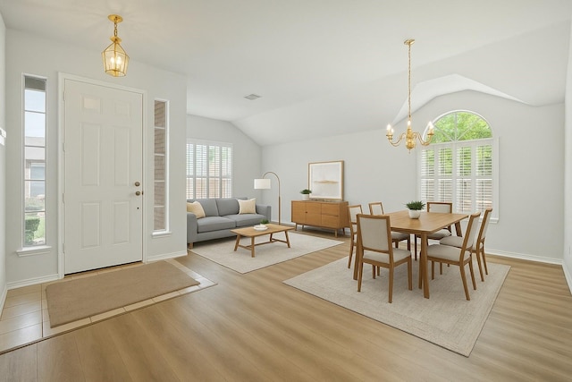 2402 Greenfield Cir, Garland, TX 75040 - dining room featuring lofted ceiling, a chandelier, light wood finished floors, and baseboards
