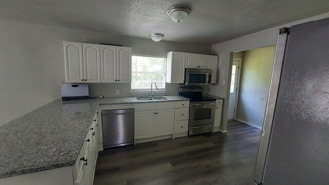 1107 Beech S, Bonham, TX 75418 - kitchen with appliances with stainless steel finishes, a sink, white cabinetry, light stone countertops, and dark wood finished floors
