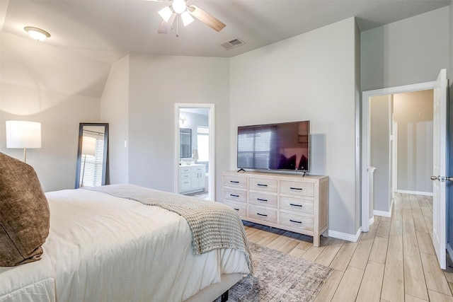 bedroom with light wood-type flooring, baseboards, and ensuite bathroom