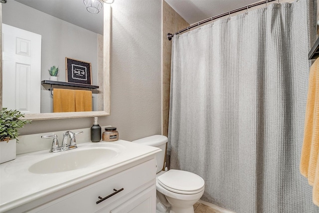 bathroom featuring a textured wall, toilet, vanity, and a shower with shower curtain