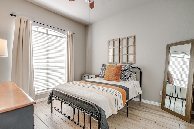 bedroom featuring multiple windows, light wood-style flooring, and baseboards