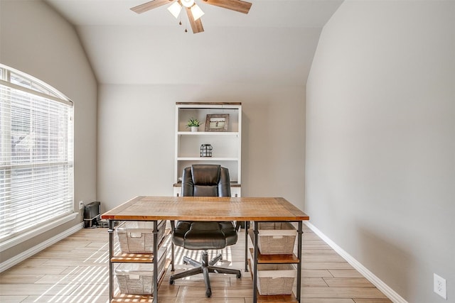 office featuring ceiling fan, vaulted ceiling, light wood-style floors, and baseboards