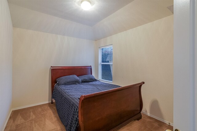 8115 Guadalupe Rd, Arlington, TX 76002 - bedroom with carpet floors, baseboards, and lofted ceiling