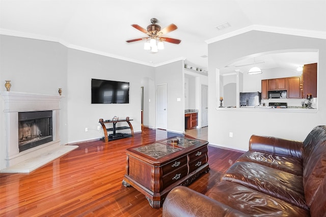 8115 Guadalupe Rd, Arlington, TX 76002 - living room with a ceiling fan, vaulted ceiling, arched walkways, wood finished floors, and a fireplace with raised hearth