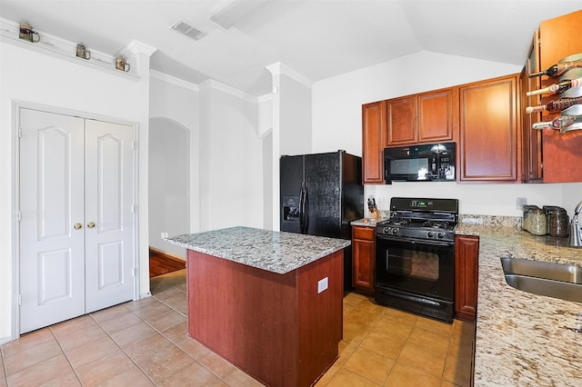 8115 Guadalupe Rd, Arlington, TX 76002 - kitchen with black appliances, arched walkways, a center island, light tile patterned floors, and light stone counters