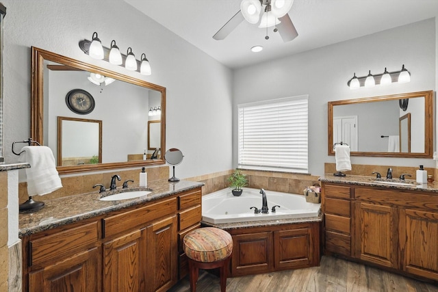 2210 Ridgewood Dr, Bridgeport, TX 76426 - full bathroom with two vanities, a whirlpool tub, ceiling fan, and wood finished floors