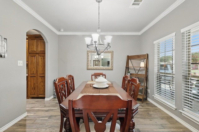 2210 Ridgewood Dr, Bridgeport, TX 76426 - dining area with arched walkways, a chandelier, light wood-type flooring, ornamental molding, and baseboards