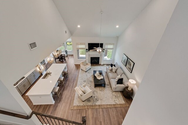 3594 Dover Dr, Mckinney, TX 75069 - living area featuring wood finished floors, recessed lighting, high vaulted ceiling, a fireplace, and baseboards