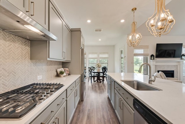 3594 Dover Dr, Mckinney, TX 75069 - kitchen with under cabinet range hood, a sink, stainless steel appliances, gray cabinetry, and a fireplace