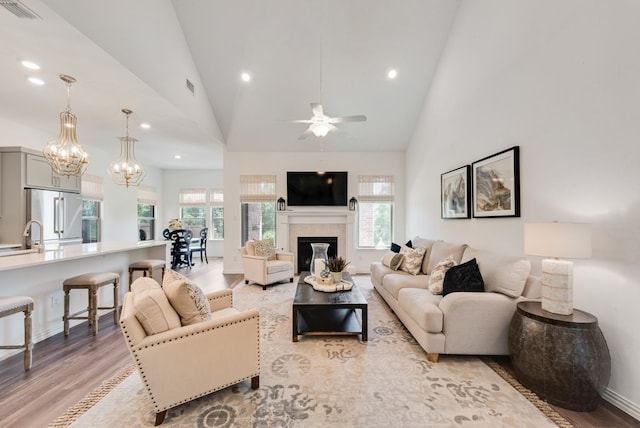 3594 Dover Dr, Mckinney, TX 75069 - living room with light wood-style flooring, recessed lighting, a ceiling fan, high vaulted ceiling, and a chandelier