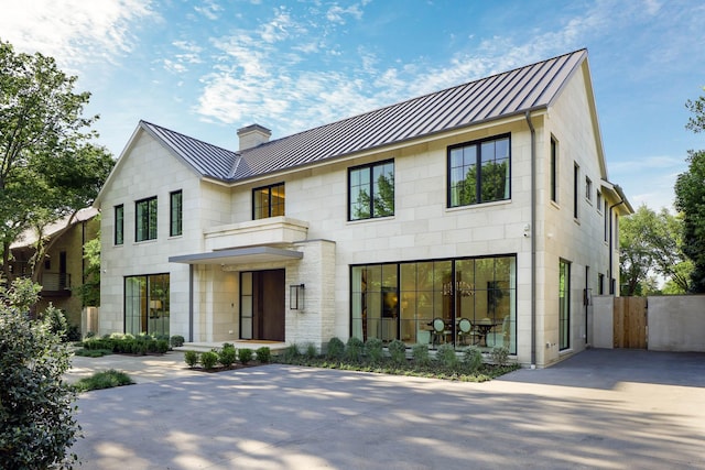 3906 Shenandoah St, Highland Park, TX 75205 - view of front of home featuring a standing seam roof, a chimney, metal roof, and fence