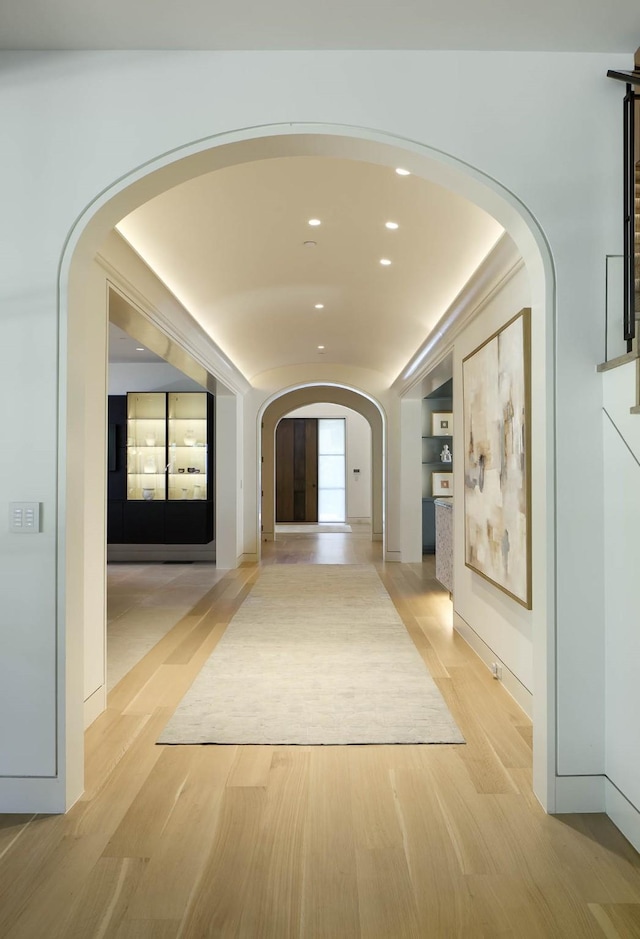 3906 Shenandoah St, Highland Park, TX 75205 - hallway featuring arched walkways, light wood-style floors, and recessed lighting