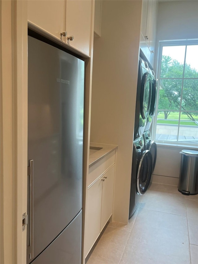 3906 Shenandoah St, Highland Park, TX 75205 - laundry area with light tile patterned flooring, plenty of natural light, and stacked washing machine and dryer