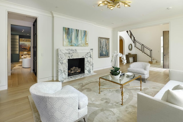 3906 Shenandoah St, Highland Park, TX 75205 - living area featuring arched walkways, crown molding, stairs, light wood-style flooring, and a high end fireplace