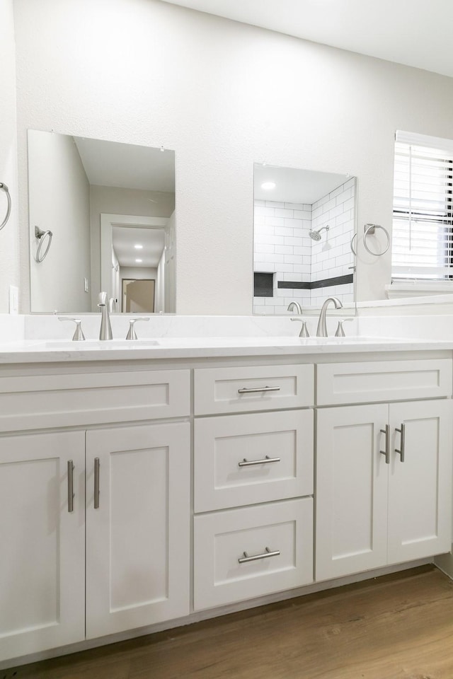 7300 Frances Ct, North Richland Hills, TX 76182 - bathroom featuring wood finished floors, double vanity, and a tile shower