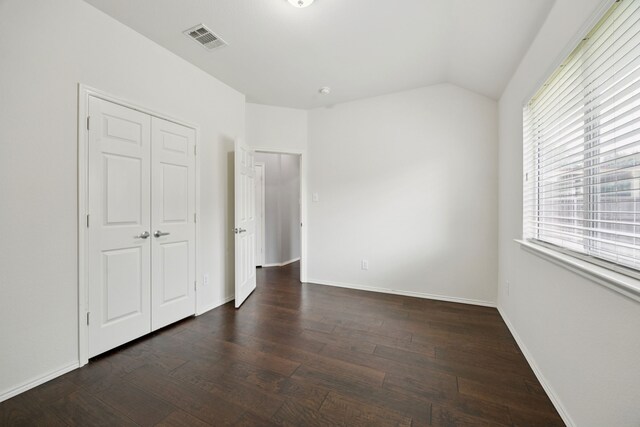 9712 Hedge Bell Dr, Mckinney, TX 75072 - unfurnished bedroom featuring dark wood-style floors, vaulted ceiling, baseboards, and a closet