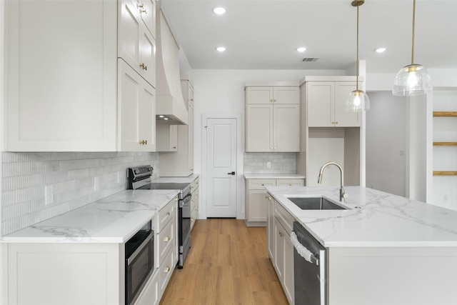 2915 NW Loraine St, Fort Worth, TX 76106 - kitchen with a sink, stainless steel appliances, light wood finished floors, an island with sink, and backsplash