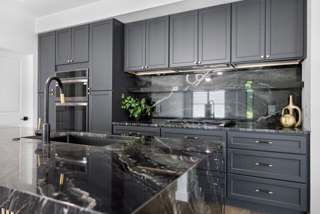 2535 Exline St, Dallas, TX 75215 - kitchen with tasteful backsplash, dark stone countertops, appliances with stainless steel finishes, and gray cabinets