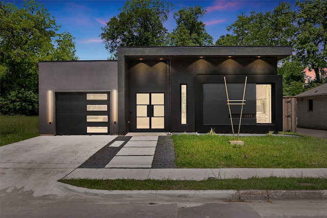 2535 Exline St, Dallas, TX 75215 - contemporary house featuring a garage, concrete driveway, stucco siding, and a yard