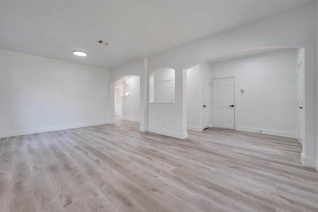 9316 Norfolk Ln, Mckinney, TX 75071 - unfurnished living room with arched walkways, light wood-style flooring, and baseboards