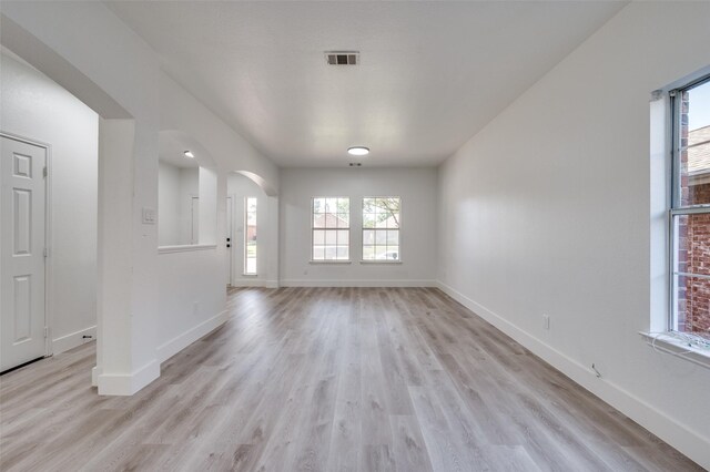 9316 Norfolk Ln, Mckinney, TX 75071 - unfurnished dining area with arched walkways, light wood-style flooring, and baseboards