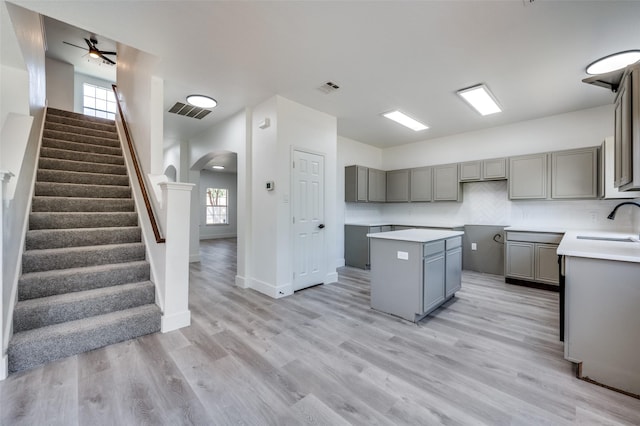 9316 Norfolk Ln, Mckinney, TX 75071 - kitchen with gray cabinets, arched walkways, a sink, light wood-type flooring, and ceiling fan