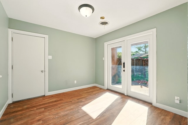doorway to outside featuring wood finished floors and baseboards