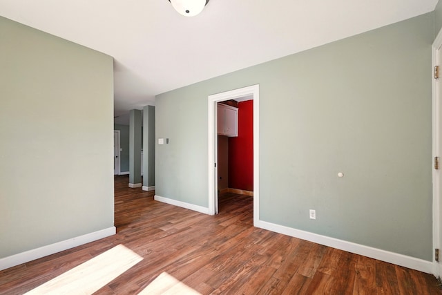 empty room with baseboards and wood finished floors