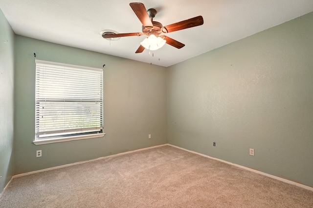 unfurnished room with carpet floors, a ceiling fan, and baseboards