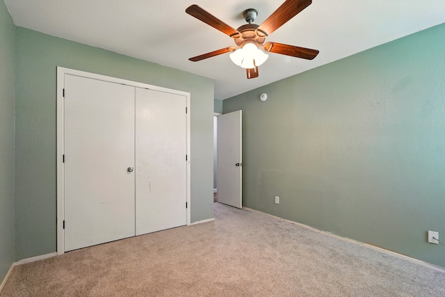unfurnished bedroom with carpet floors, a closet, ceiling fan, and baseboards