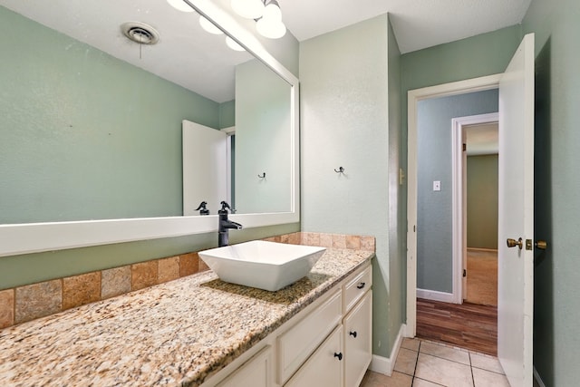 bathroom with tile patterned flooring, vanity, and baseboards